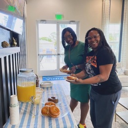 two women smiling and holding food