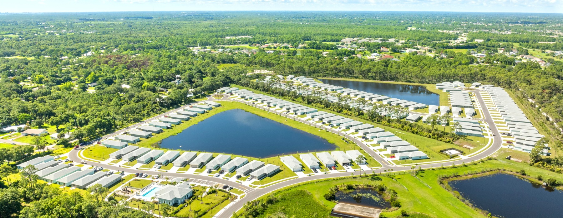 a neighborhood with a lake in the middle of a field